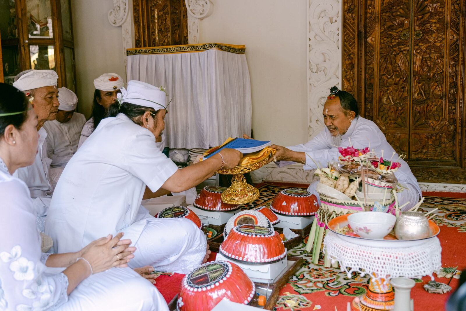 Offerings blessed at a shrine by the pemangku. A ceremony is not entertainment — watch with the respect you'd want at your own.