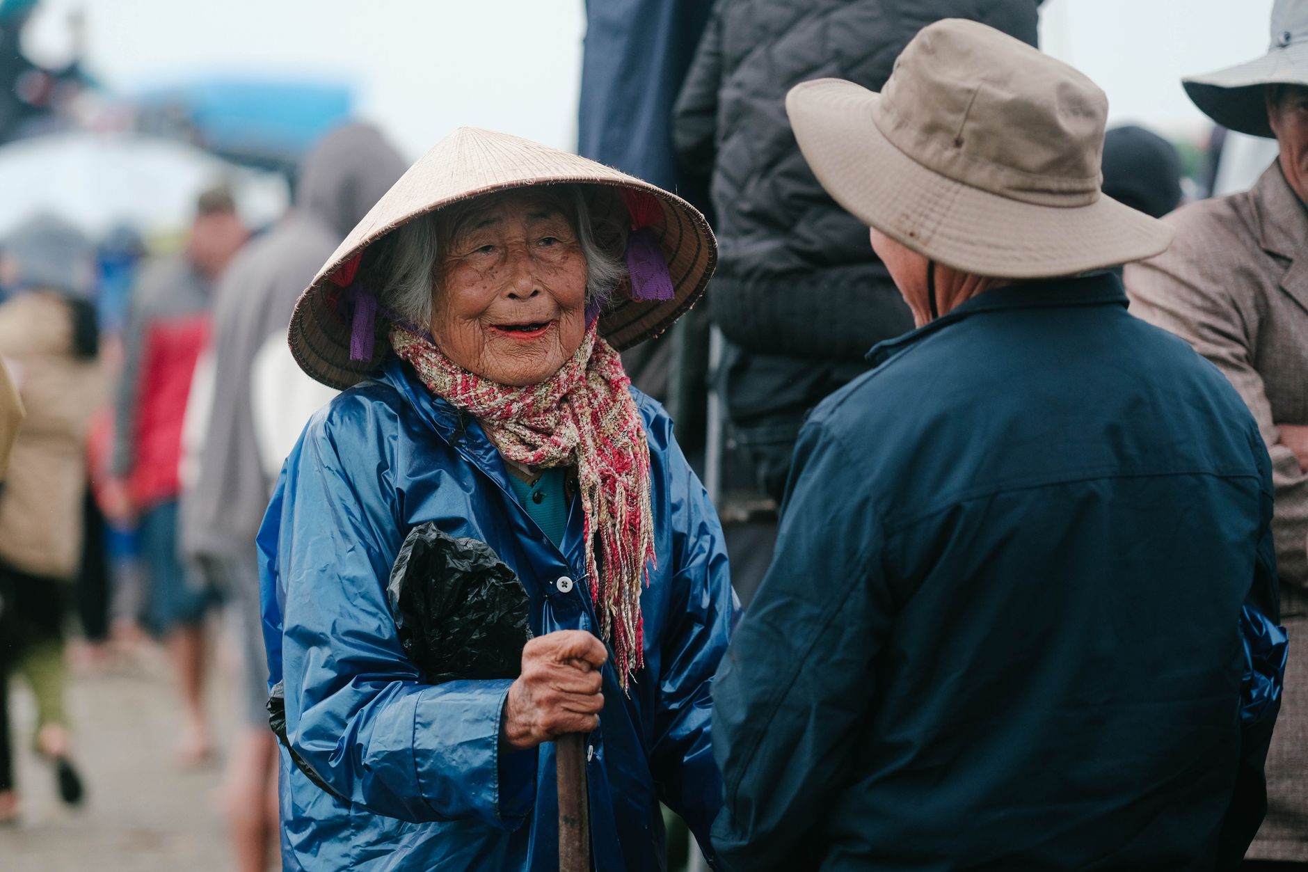 An elderly woman in conversation at a market
