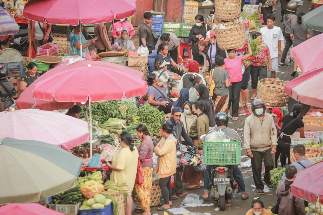 A busy Bali market under pink umbrellas
