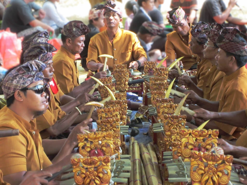 Gold-costumed musicians playing interlocking parts on the bronze keys.