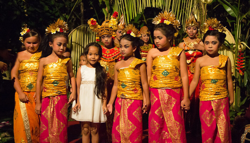 Young Legong dancers in gold and magenta before a performance.