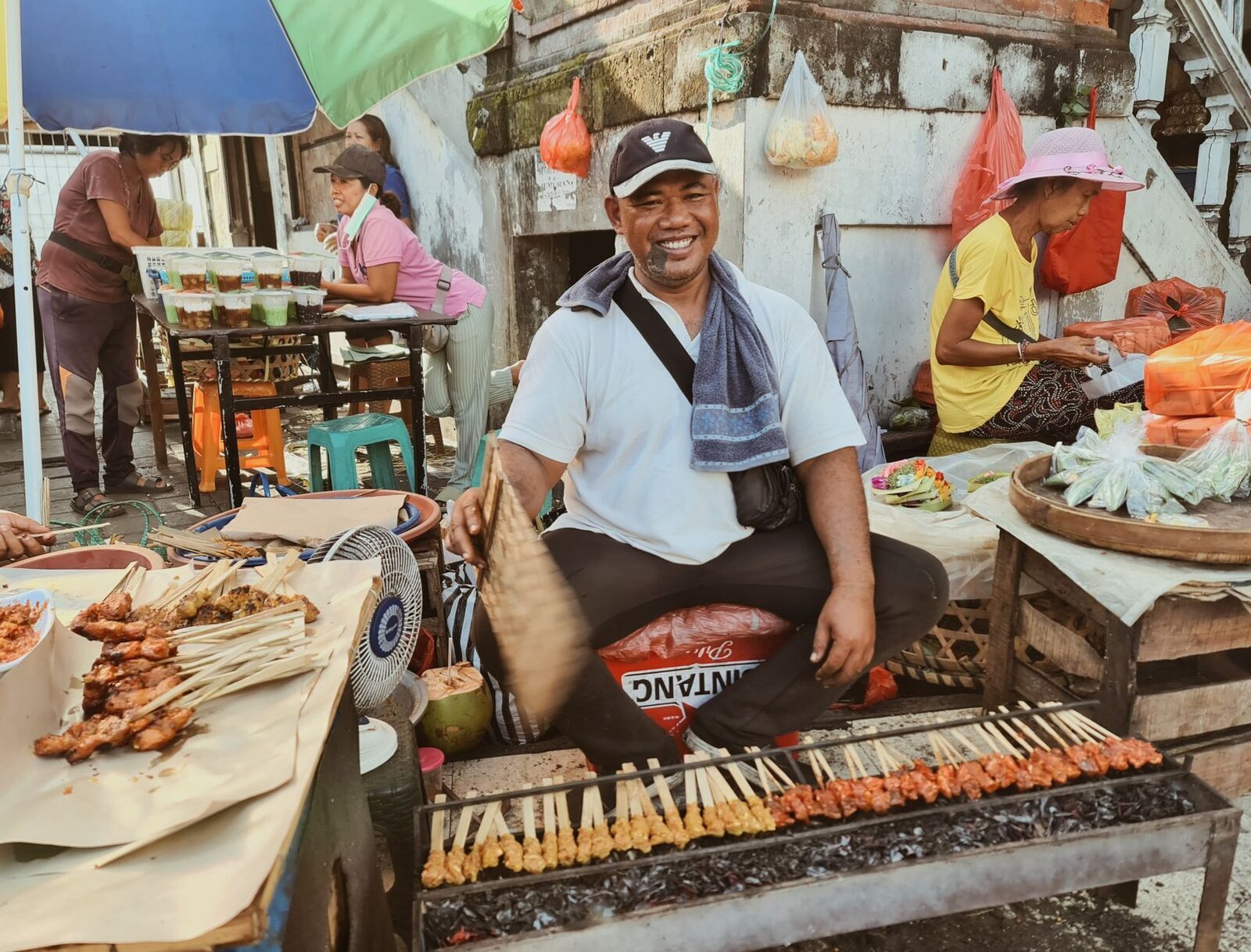 A street-side stall grilling satay to order — the kind of high-turnover cooking worth following the locals to.
