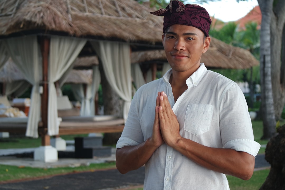 A young Balinese man greeting with palms pressed at his chest
