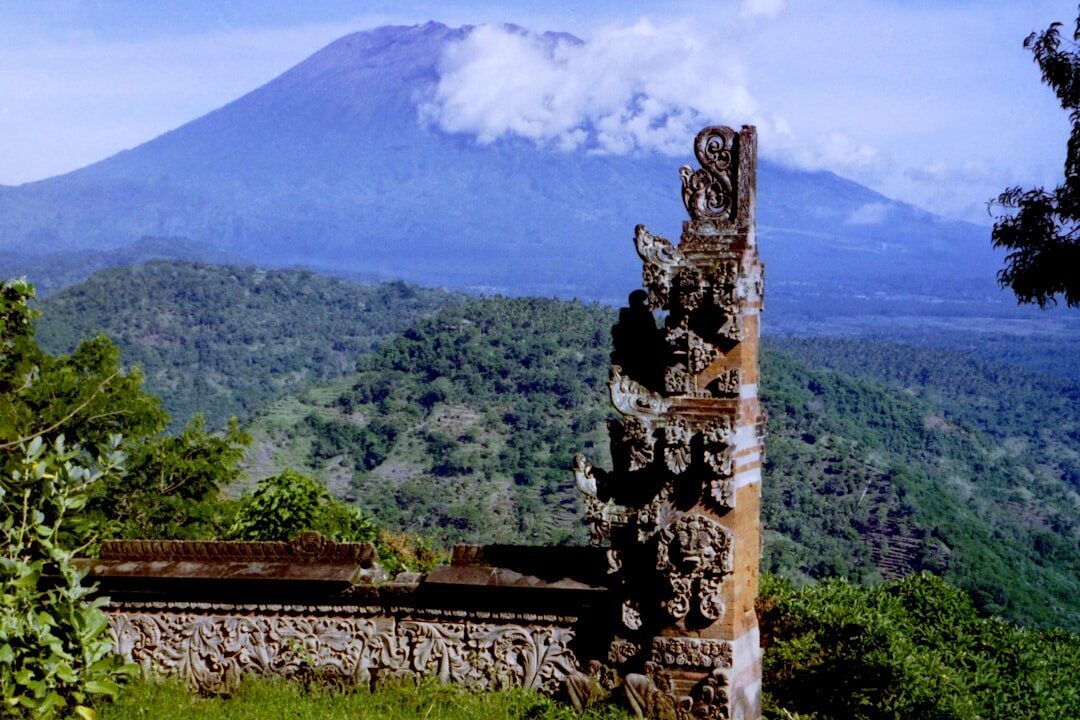A carved split gate at Besakih with the bulk of Mount Agung rising behind.