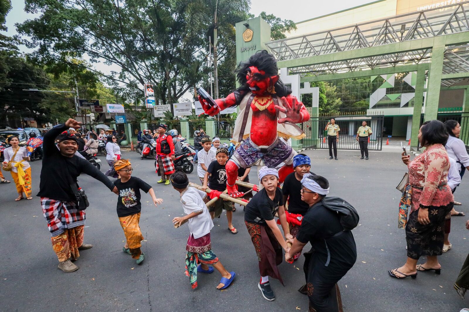The parade itself: an effigy carried and spun through a village street as the crowd presses in.