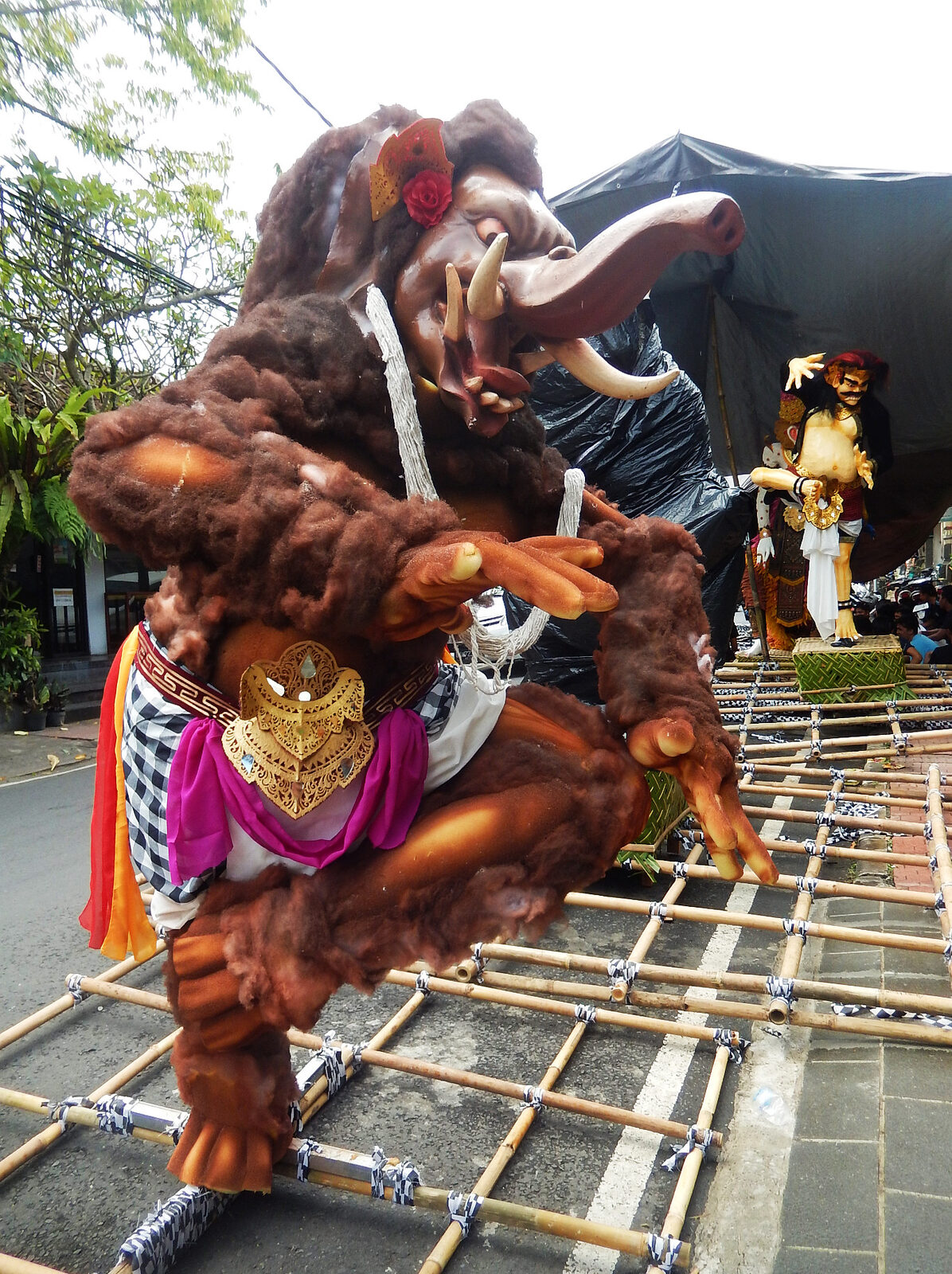 A shaggy demon lashed to its bamboo lattice, ready to be carried through the streets.