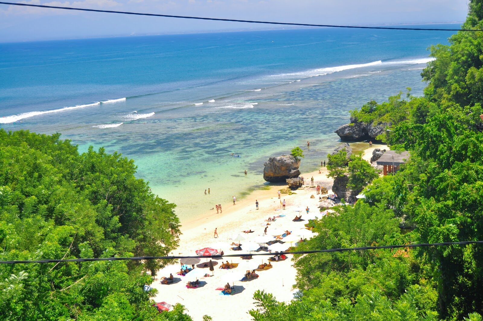 Padang Padang from above: a pocket of sand and umbrellas hemmed in by rock.