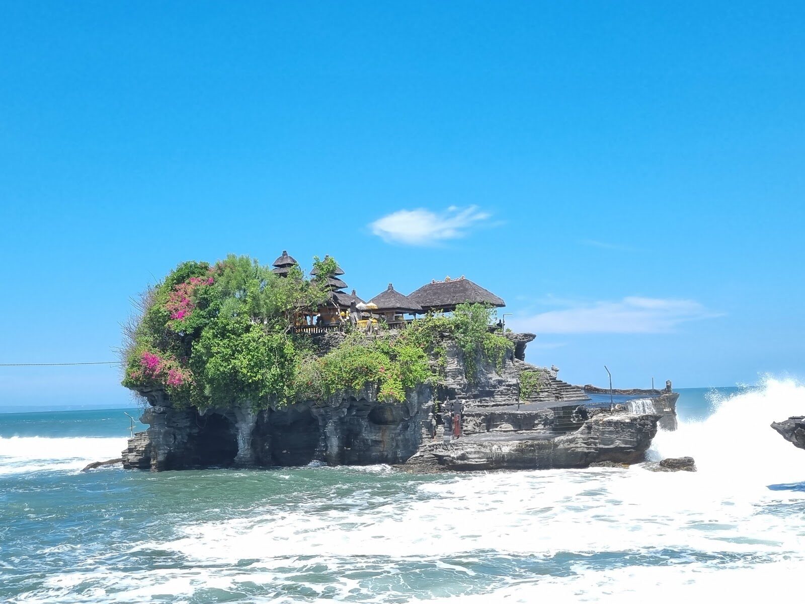 Pura Tanah Lot on its tidal rock offshore — the famous sea temple, seen in clear daylight.