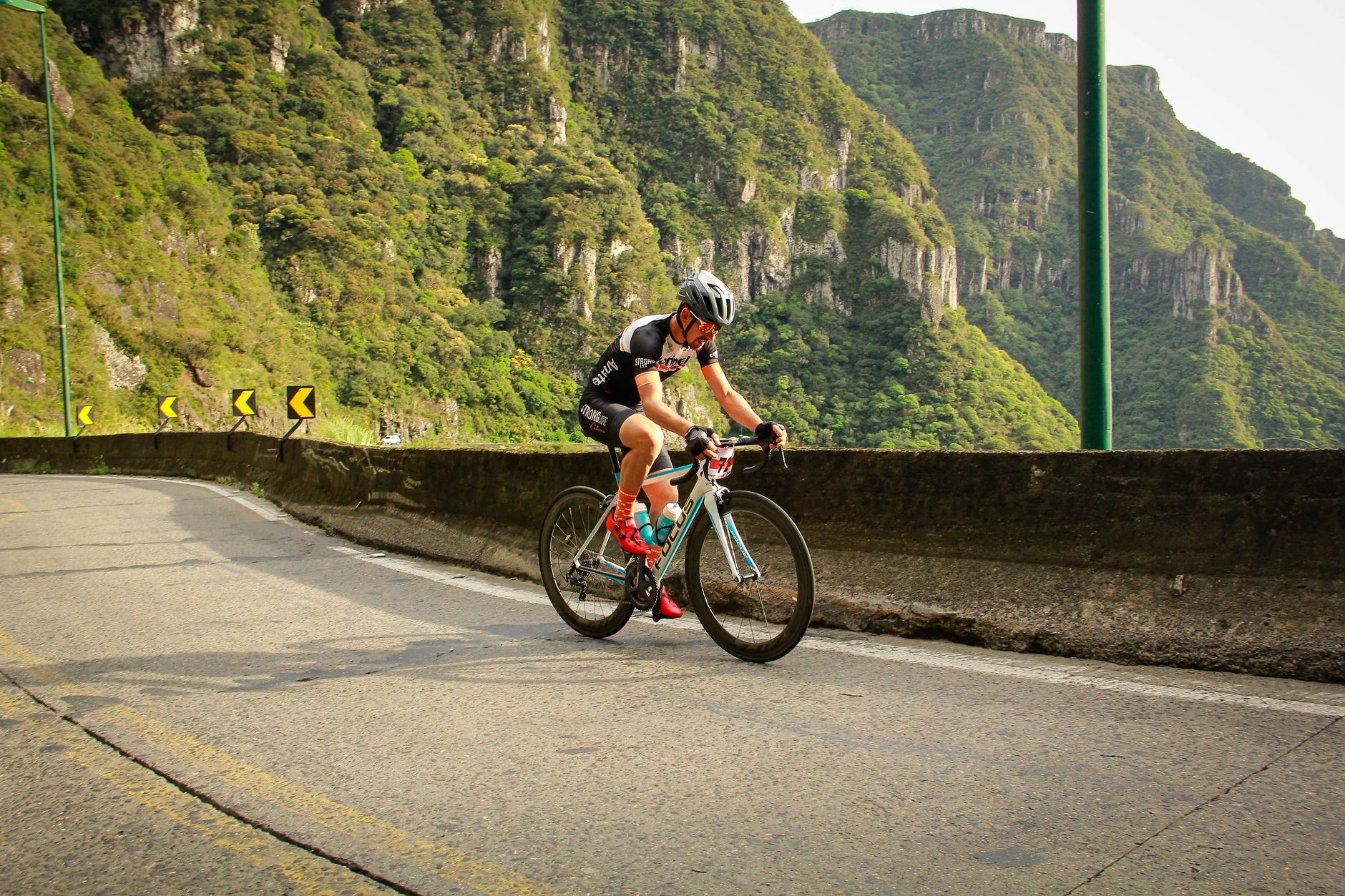 A road cyclist climbing a scenic Bali mountain road