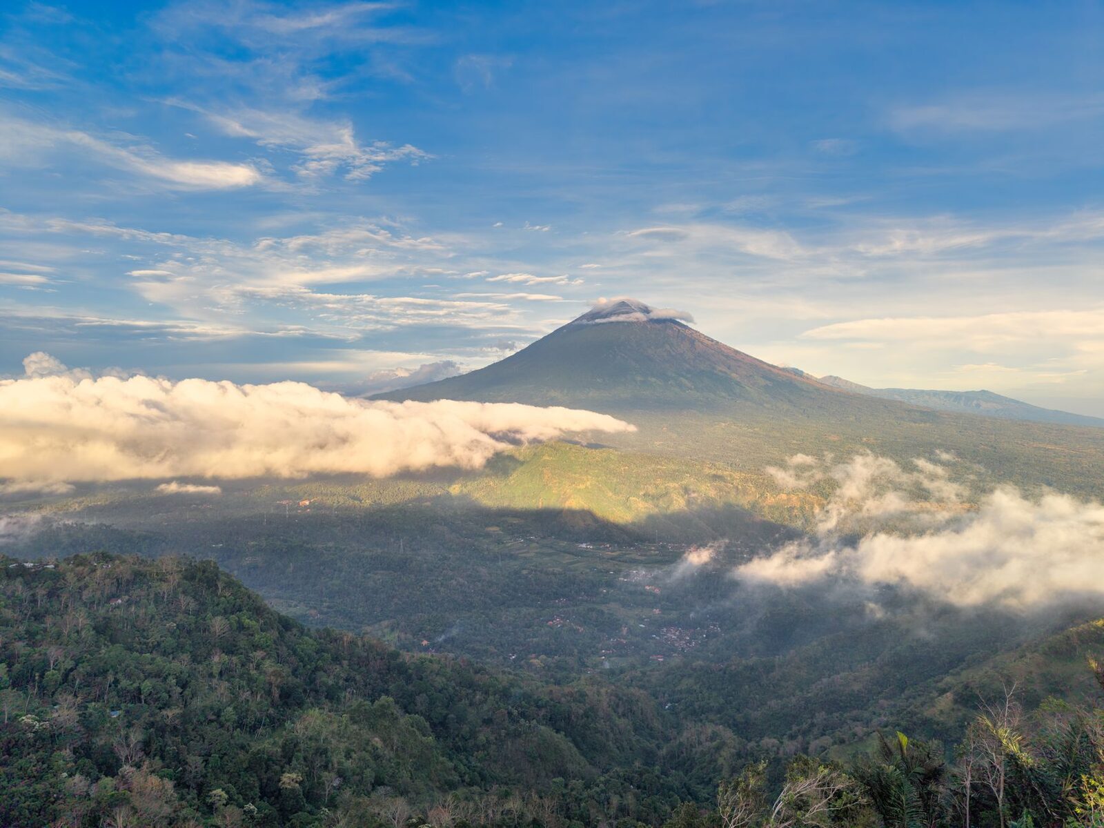 The cone breaking through the clouds, seen from the eastern highlands.