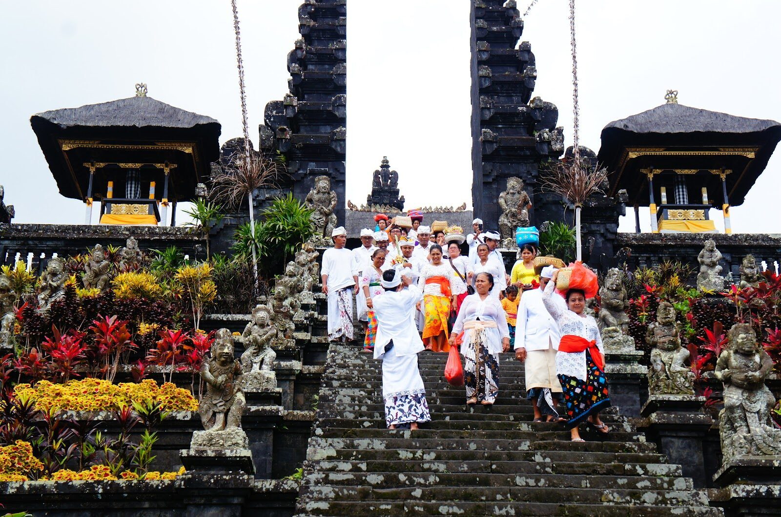 Worshippers in ceremonial dress climbing the steps with offerings — a living sanctuary, not just a sight.
