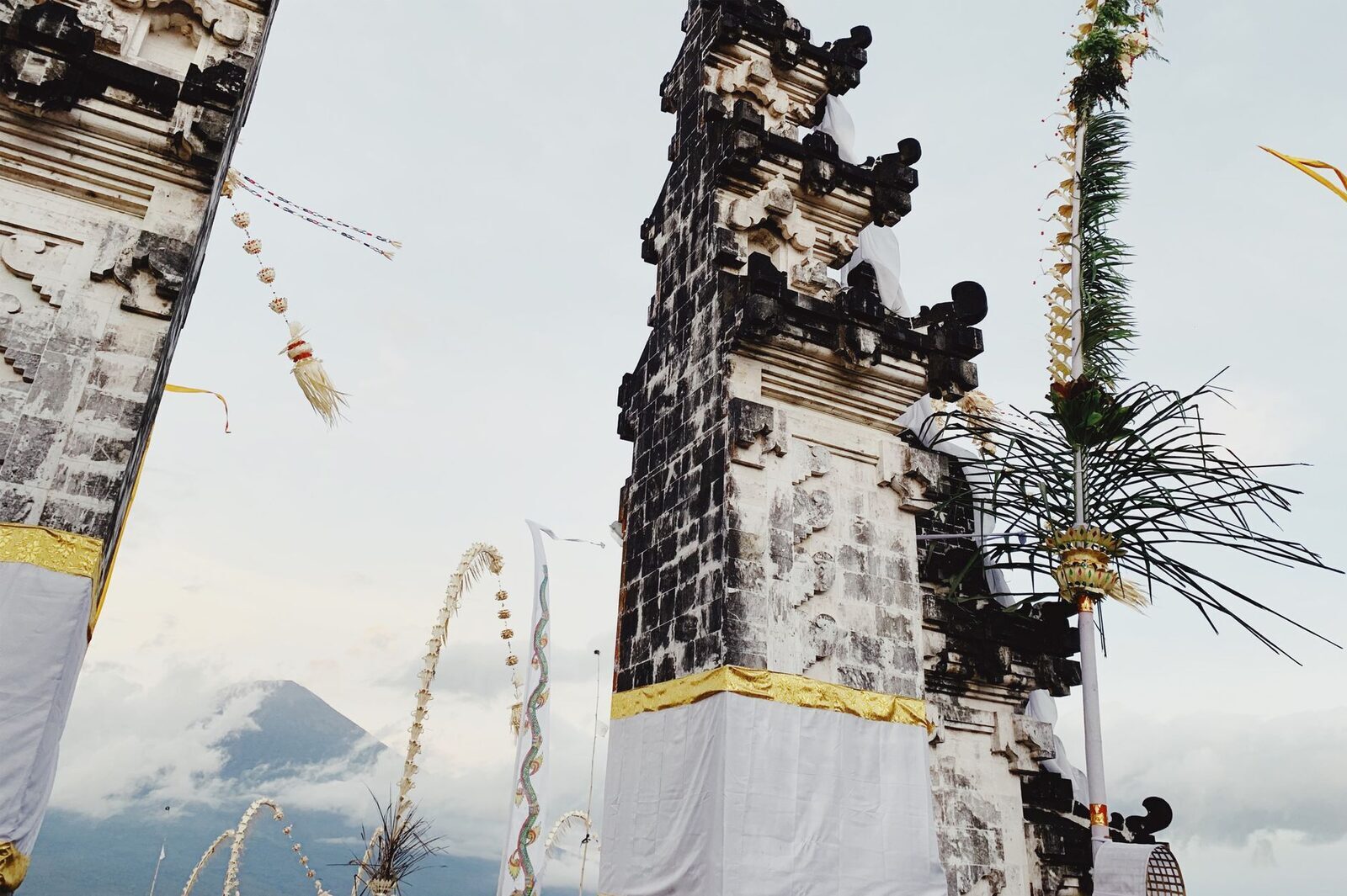 Penjor and temple decoration, Agung faint in the distance.
