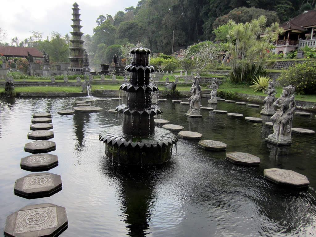 Stepping stones threading between the tiered fountain and the stone guardians.