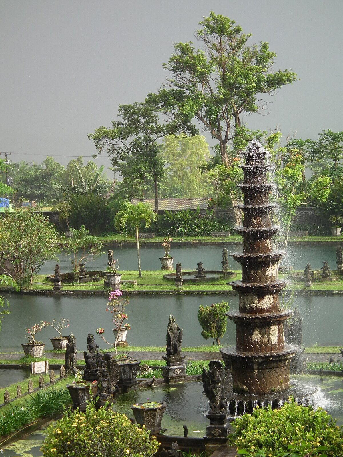 The tall tiered fountain tower rising from the koi pond.
