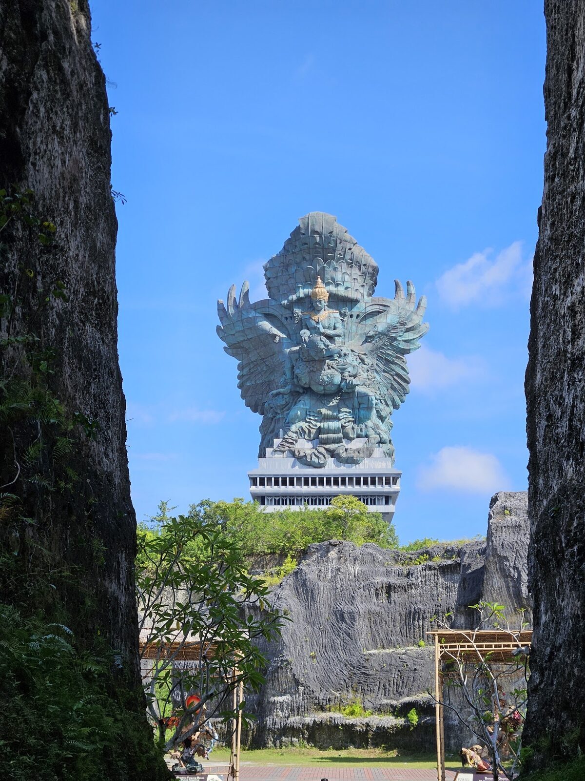 The statue rising in the gap between two towering blocks of quarried limestone.