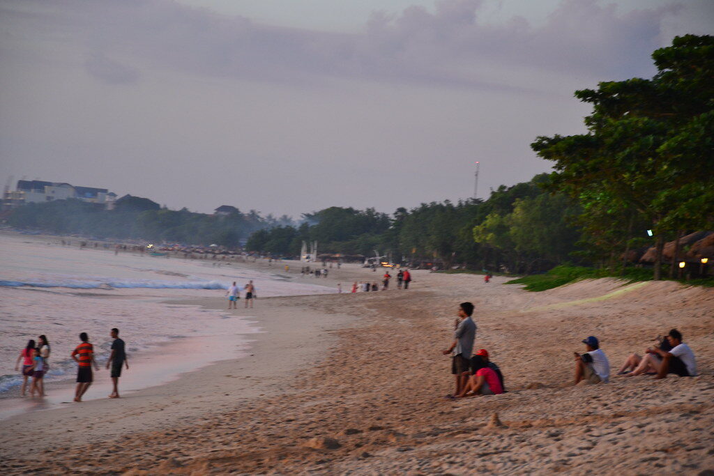 Beachgoers walking the wide, easy shoreline.