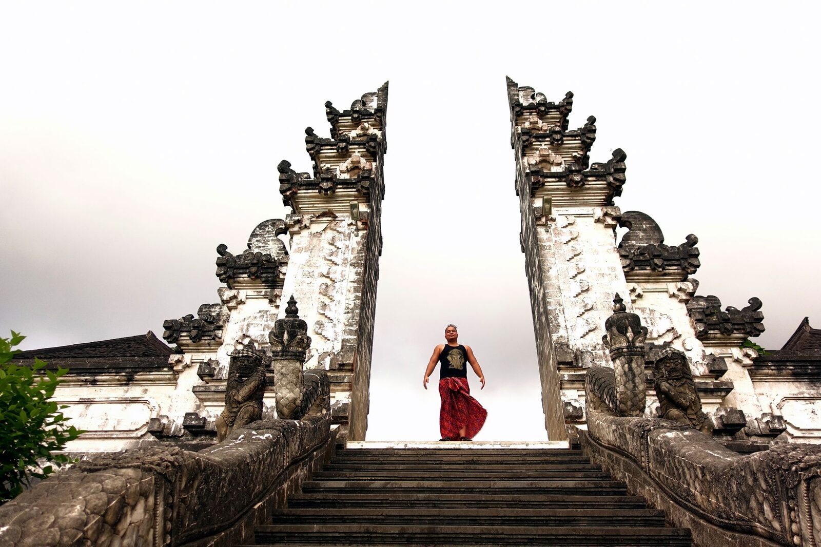 A visitor poses on the stair between the gate's two halves — the shot everyone queues for.