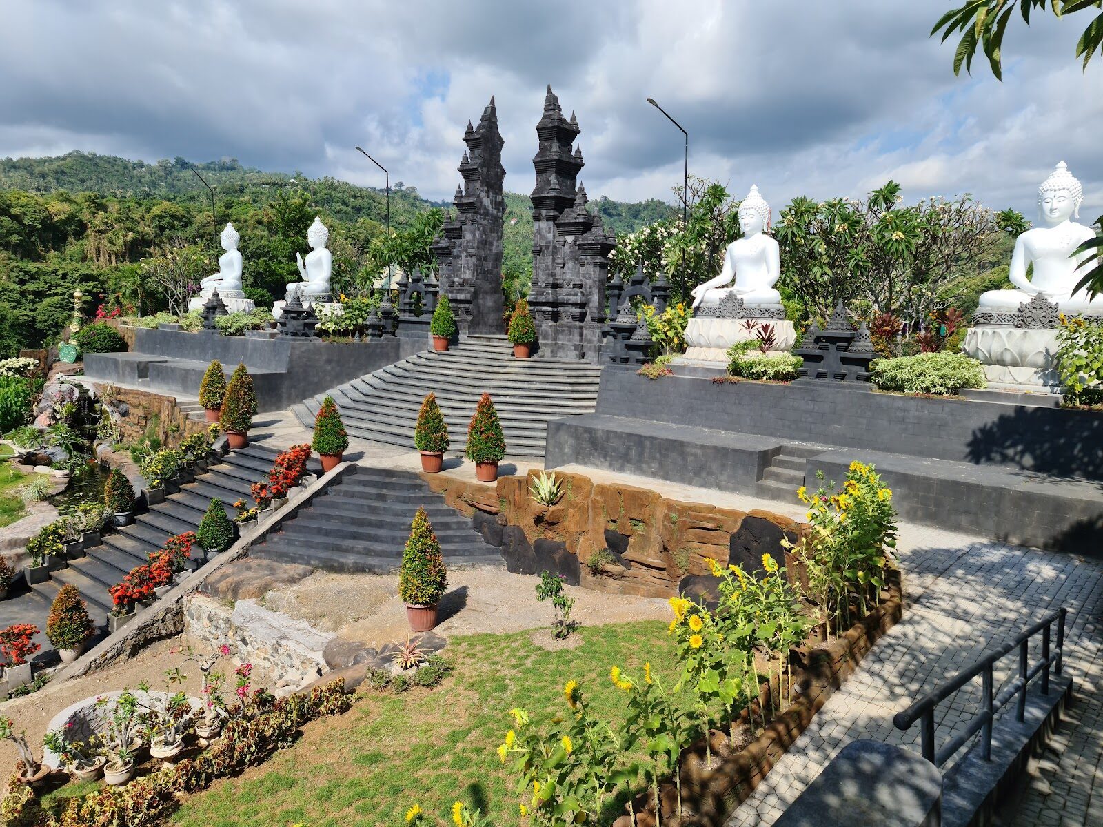 White Buddha figures lining the terraces at Brahmavihara-Arama.