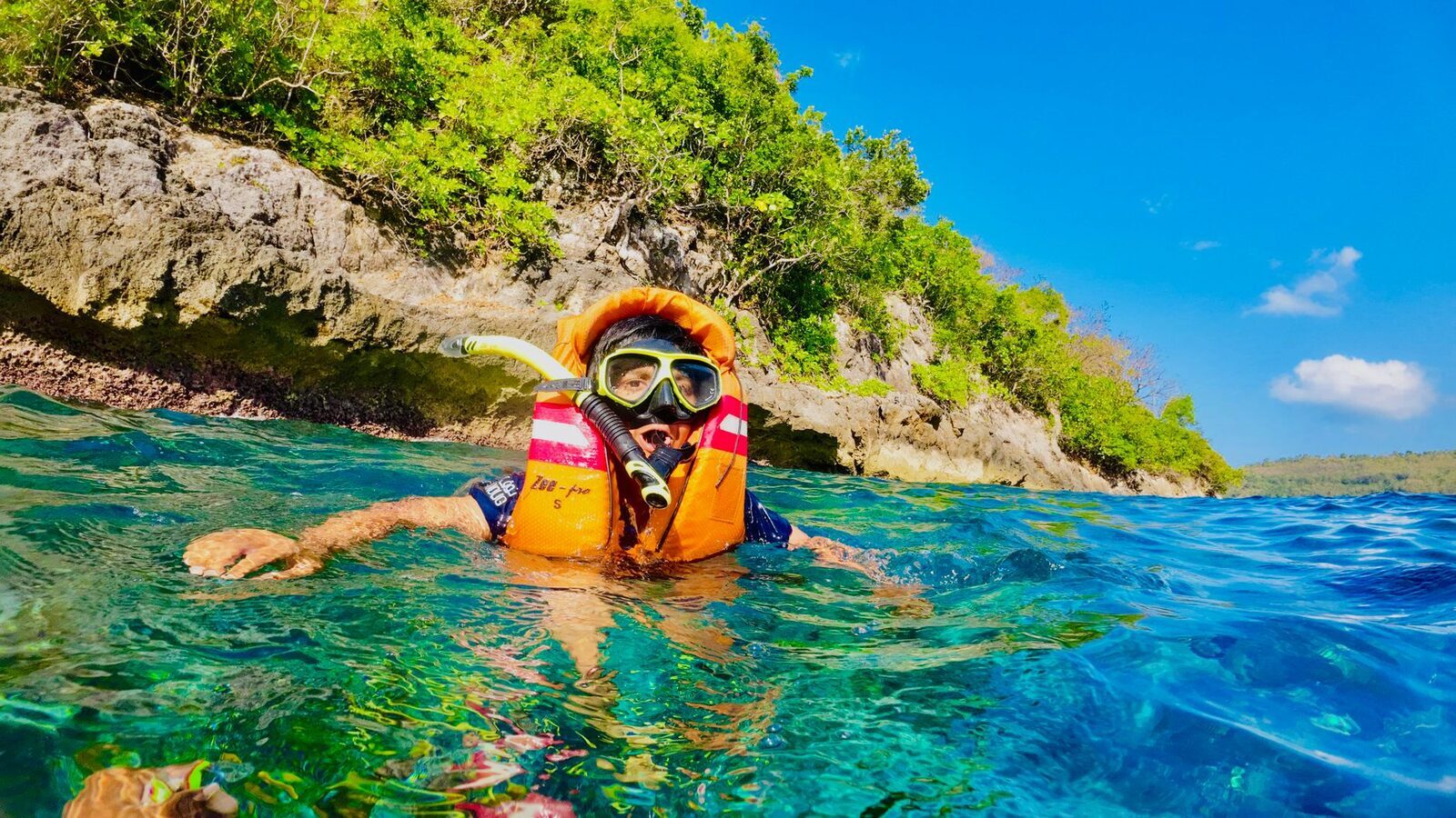 A snorkeller in a life jacket over a reef — the low-key format most trips run. (Generic Bali snorkel scene.)