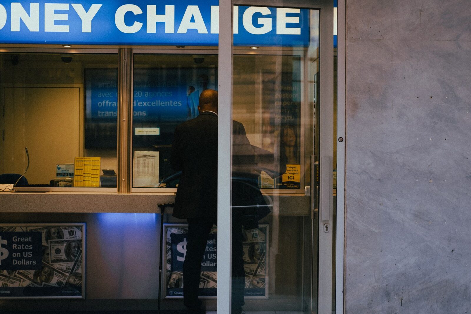 A money-changer counter. The rate on the board is the bait; the loss happens in the count.