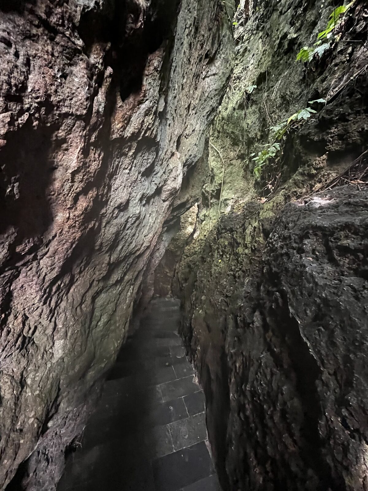 The narrow cleft in the rock — the slot-canyon staircase that's the only way down to the cove.