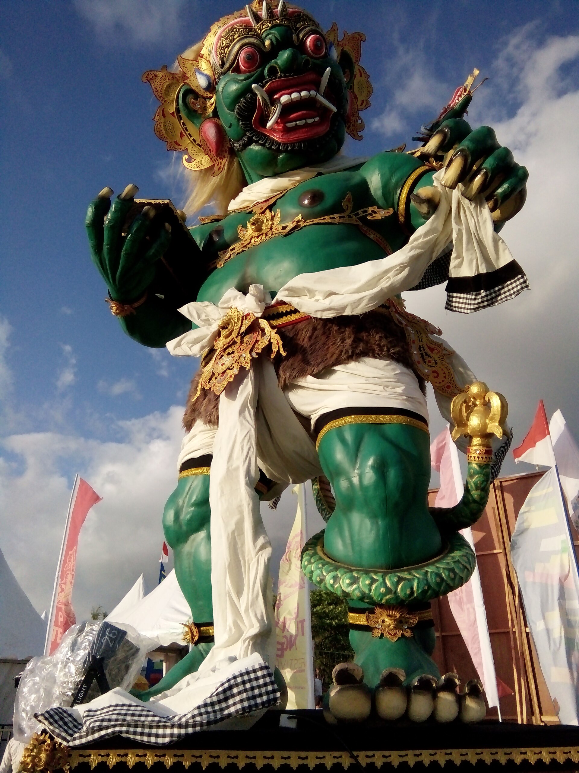 A green guardian-giant (Bhuta) statue near Pura Petitenget