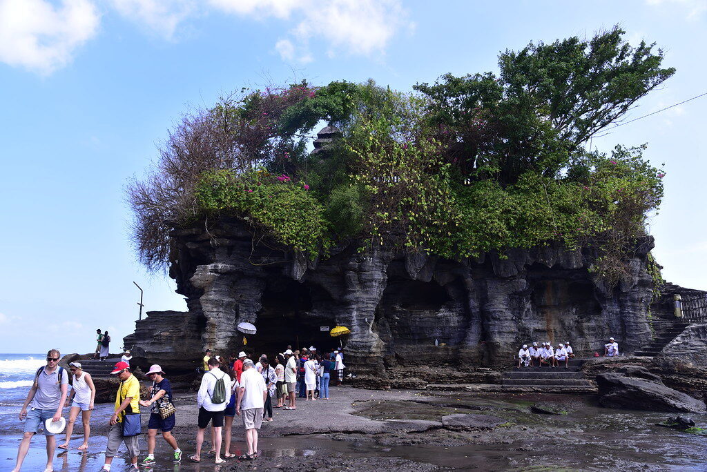 Low tide: visitors file across the exposed rock right up to the foot of the temple.