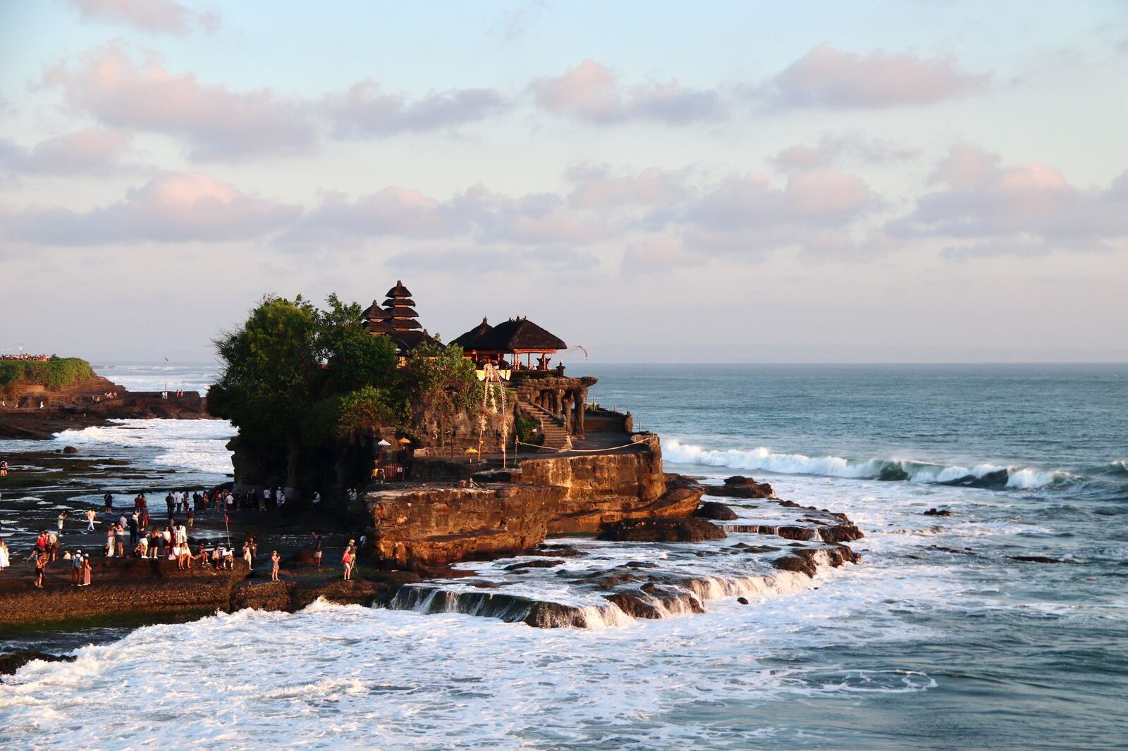 The islet from the cliff path, waves wrapping the base.