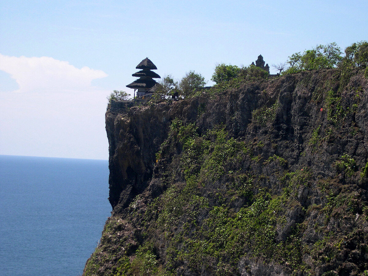 The green point the temple sits on, dropping sheer to the ocean.