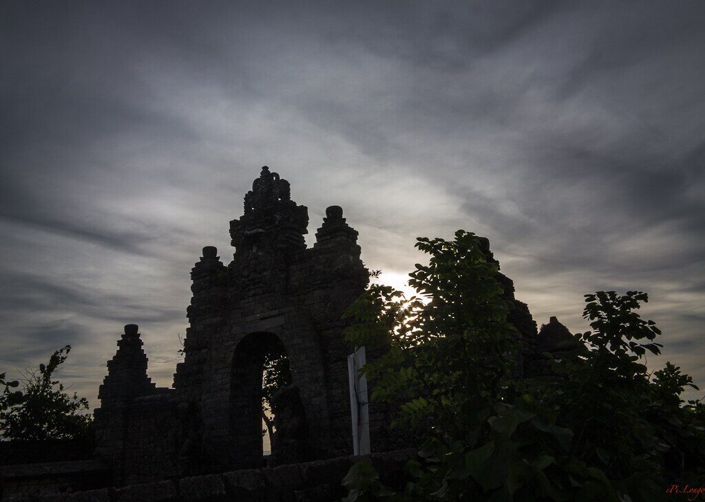 A temple gate black against the last light.