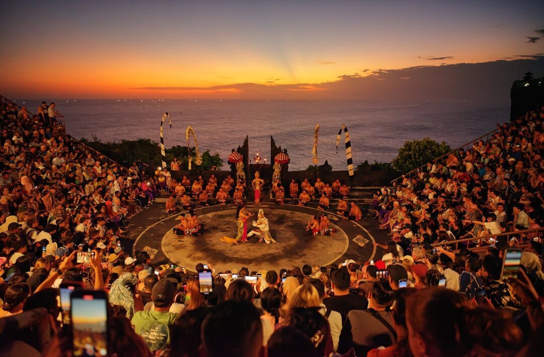 The lit fire circle at dusk as the sea goes dark beyond the cliff.
