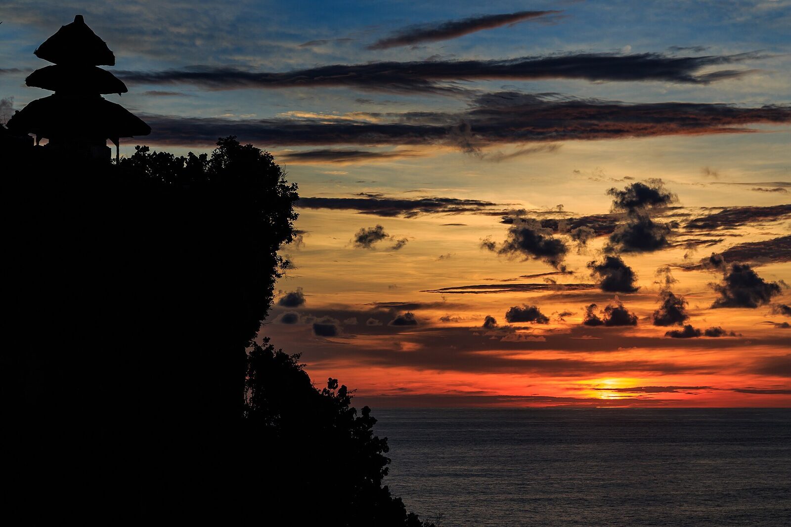 A fiery red sunset behind the Uluwatu shrines.