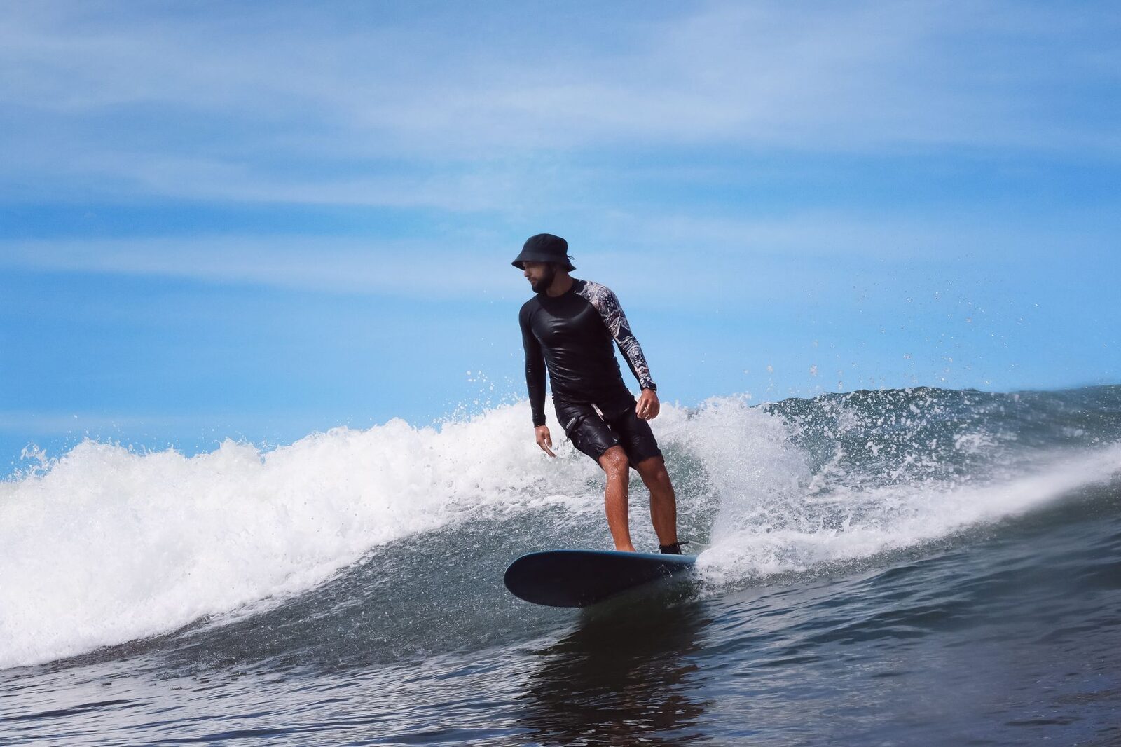 A longboarder on a mellow wave — the kind of easy left Medewi is known for.