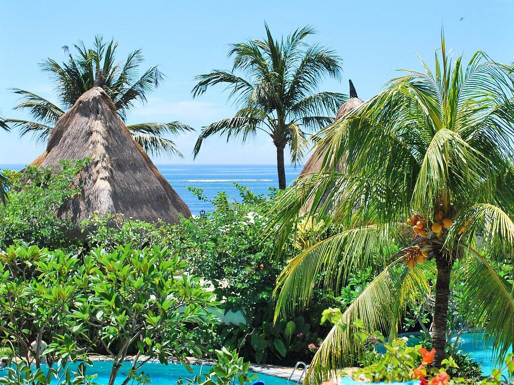 A thatched-pavilion resort pool among the palms — the family-holiday standard here.
