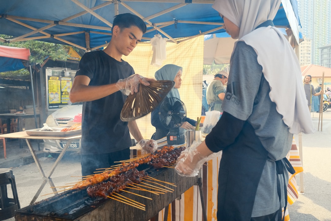 Satay grilling over charcoal at a Langkawi night market stall.